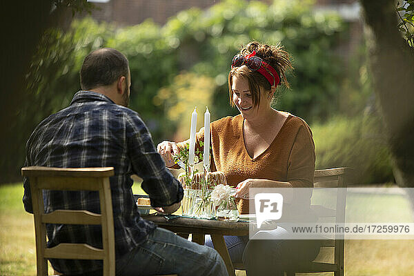 Glückliches Paar genießt Kuchen am Tisch im Sommergarten