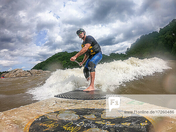 Fotograf Skip Brown surft mit dem Stand Up Paddle auf einer anspruchsvollen Wildwasserwelle auf dem Potomac River  Maryland  Vereinigte Staaten von Amerika  Nordamerika