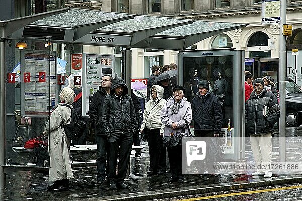 Shopping street  Merchant City  bus stop  bus shelter  passers-by  waiting  rain  Glasgow  Scotland  Great Britain