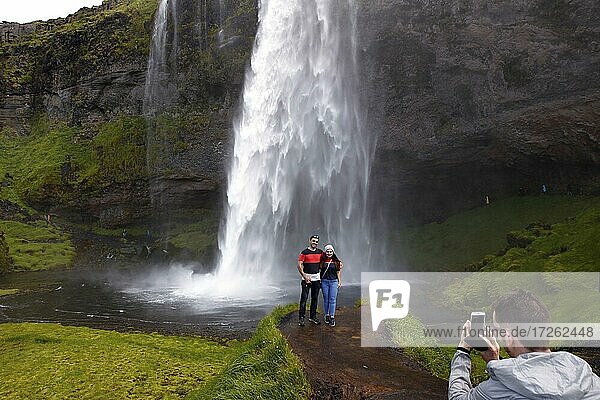 Wasserfall  Seljalandsfoss  Abbruchkante des Hochlands  Paar wird fotografiert  Südküste  Island  Europa