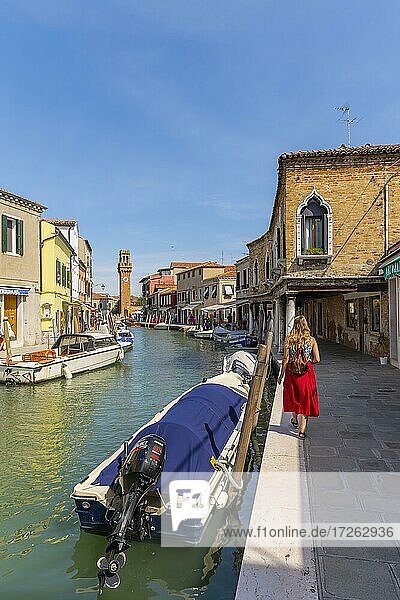 Junge Frau an einem Kanal  Häuser und Boote am Kanal Rio del Vetrai  Glockenturm St. Stefano  Murano  Venedig  Venetien  Italien  Europa