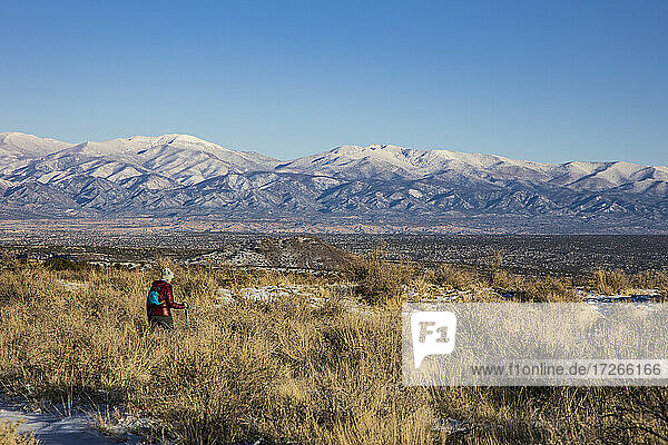 USA  New Mexico  Los Alamos  Bandelier national Monument  Tsankwai  Frau wandert in verschneiter Wüste