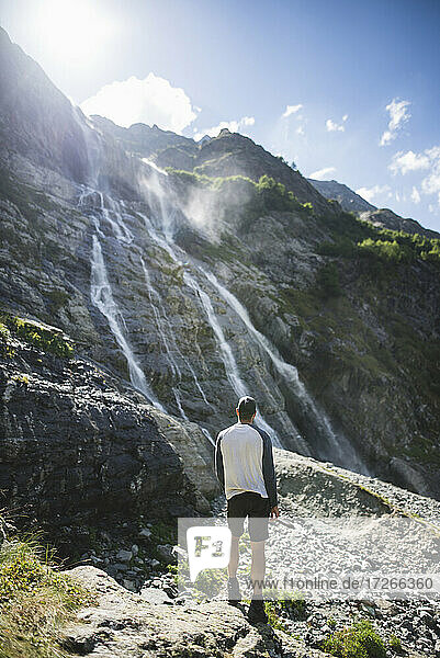 Russland  Karatschai-Tscherkessien  Arkhyz  Mann stehend in der Nähe von Sofiyskiye Vodopady Wasserfall im Kaukasus-Gebirge