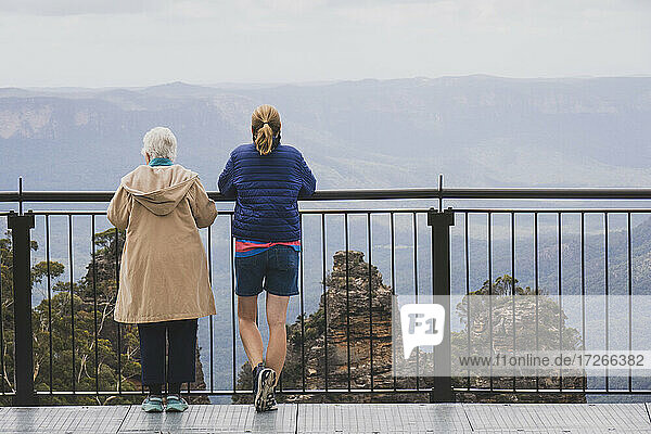 Australien  New South Wales  Rückansicht von zwei Frauen  die zusammen auf dem Aussichtspunkt Echo Point im Blue Mountains National Park stehen