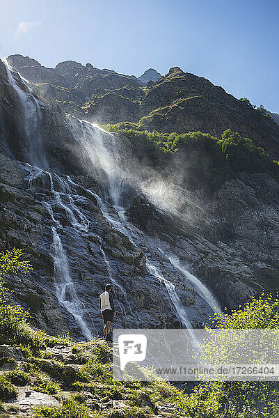 Russland  Karatschai-Tscherkessien  Arkhyz  Mann stehend in der Nähe von Sofiyskiye Vodopady Wasserfall im Kaukasus-Gebirge