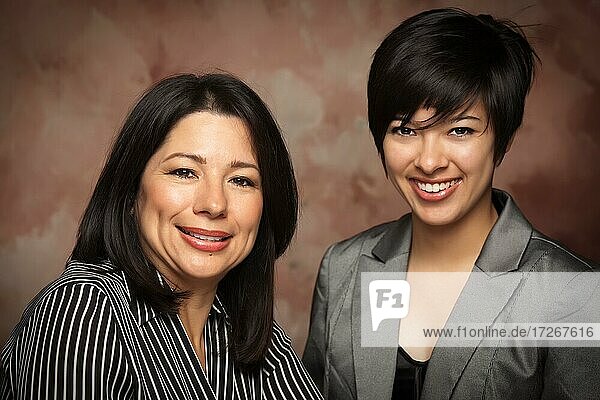 Attractive multiethnic mother and daughter studio portrait on a muslin background