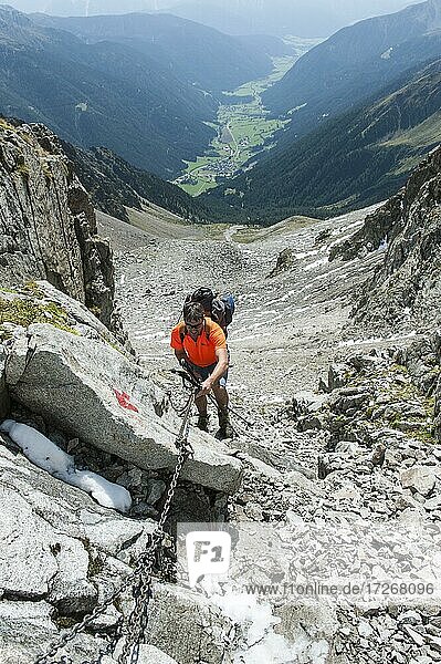 Mountaineering  climbing  mountaineer  climber climbs up a chain in a saddle  Antholzer Scharte  Antholzer Tal  Rieserfernergruppe  Naturpark Rieserferner-Ahrn  Rasen-Antholz  Rasun-Anterselva  South Tyrol  Alto Adige  Italy  Europe