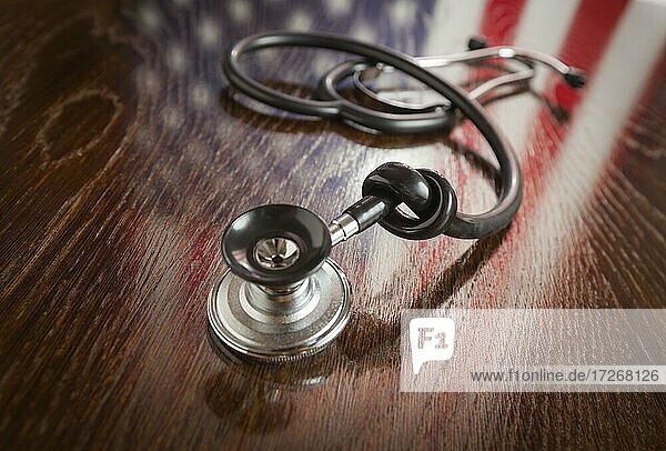 Verknotete Stethoskop mit amerikanischer Flagge Reflexion auf Holztisch