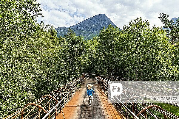 Girl walking on a very modern steel bridge  Gudbrandsjuvet  Trollstigen mountain road  Norway  Europe