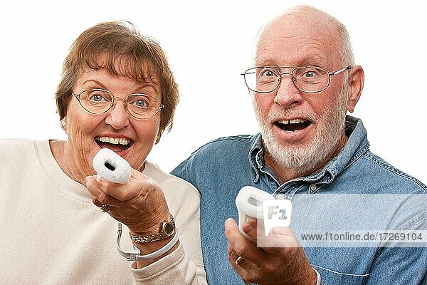 Happy senior couple play video game with remote controls on a white background