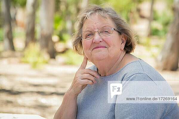 Happy content senior woman portrait outdoors at park