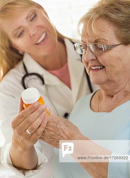 Glückliche Ärztin oder Krankenschwester  die einer älteren erwachsenen Frau ein Rezept erklärt