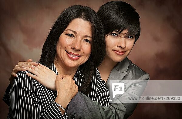Attraktive multiethnische Mutter und Tochter Studio Porträt auf einem Musselin Hintergrund