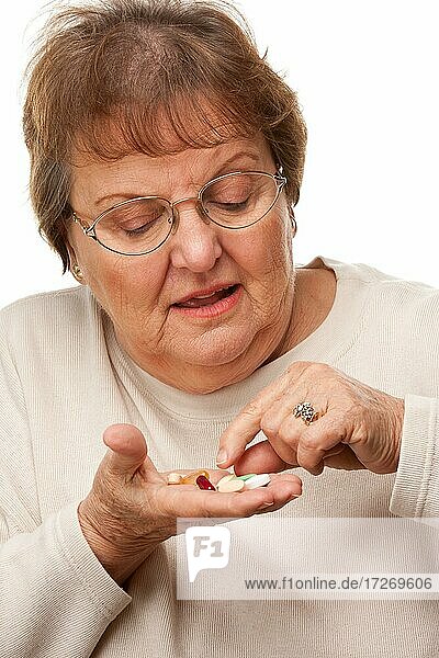 Attraktive ältere Frau und Medikamente Pillen vor einem weißen Hintergrund