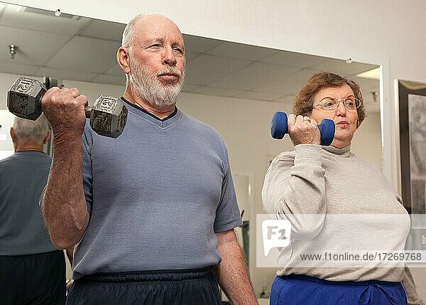 Senior adult couple working out in the gym