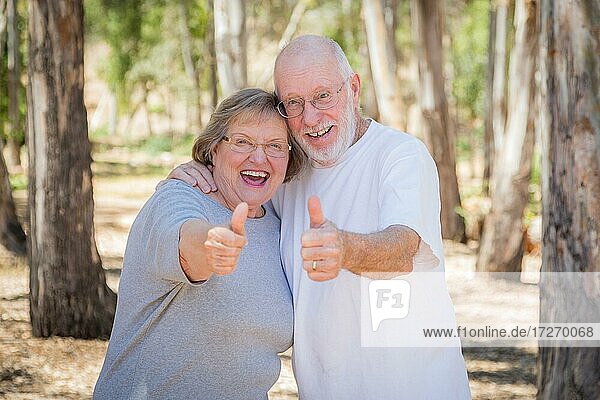 Glückliches Seniorenpaar mit Daumen nach oben im Freien