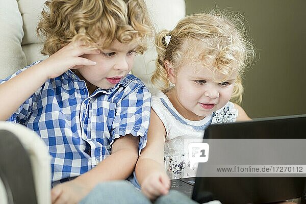 Adorable jungen Bruder und Schwester mit ihrem Computer Laptop zusammen