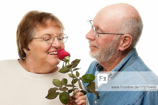Glückliches älteres Paar mit roter Rose vor einem weißen Hintergrund