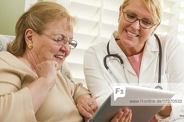 Arzt oder Krankenschwester im Gespräch mit älterer Frau mit Touchpad-Computer