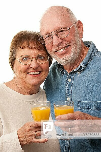 Glückliches älteres Paar mit Gläsern von Orangensaft vor einem weißen Hintergrund