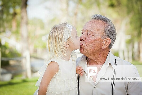 Liebender Großvater und Enkelin küssen draußen im Park