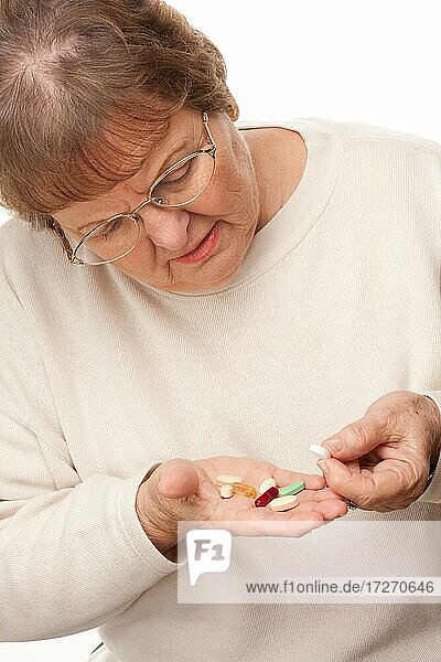 Attraktive ältere Frau und Pillen vor einem weißen Hintergrund