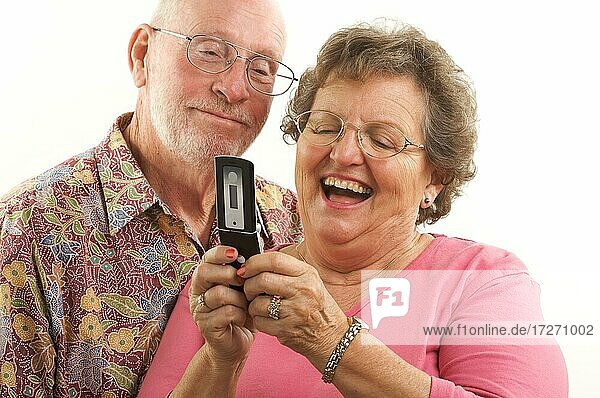 Senior couple looks at the screen of a cell phone