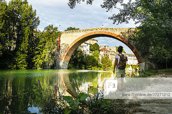 Frau steht und schaut auf die antike Brücke Ponte Della Concordia in Fossombrone  Marken  Italien