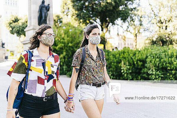 Lesbisches Paar mit Gesichtsschutzmaske auf der Straße in der Stadt