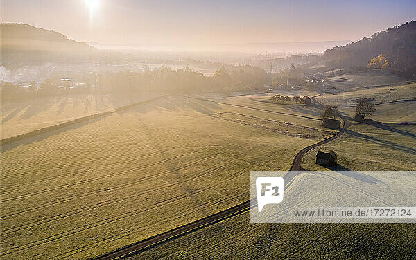 Drone view of countryside fields at foggy autumn sunrise