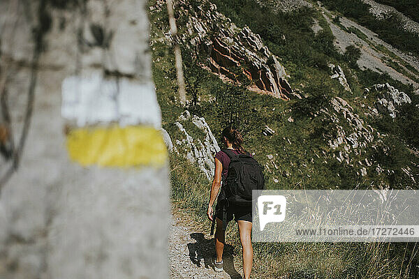 Weibliche Wanderin mit Rucksack auf der Las Xanas Route an einem sonnigen Tag