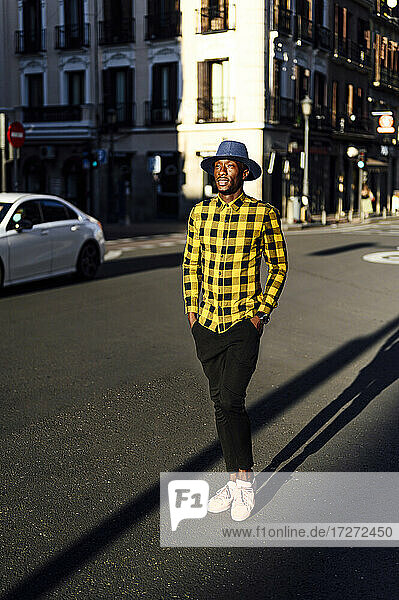 Confident african man with hands in pockets standing in city