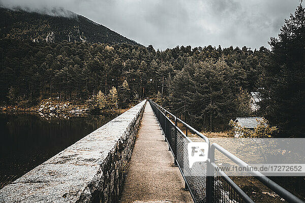 Narrow bridge over alpine lake in winter