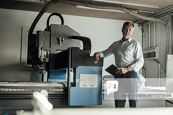 Männlicher Ingenieur mit digitalem Tablet an einer Produktionsanlage in einer Fabrik