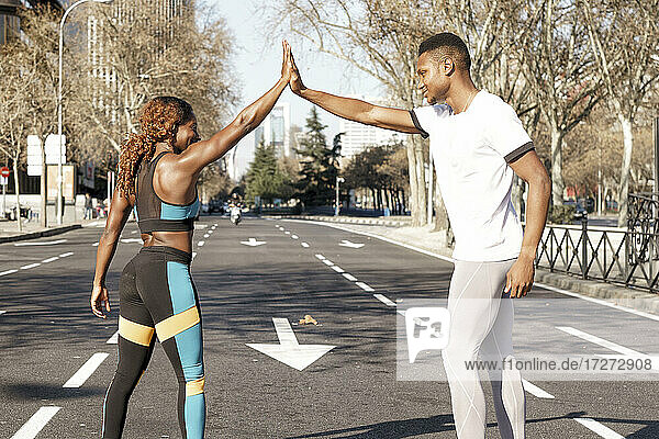 Athleten geben sich vor dem Rennen ein High Five  während sie auf der Straße in der Stadt stehen