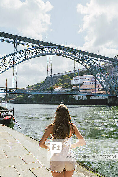 Frau steht am Fluss Douro in der Stadt an einem sonnigen Tag  Porto  Portugal
