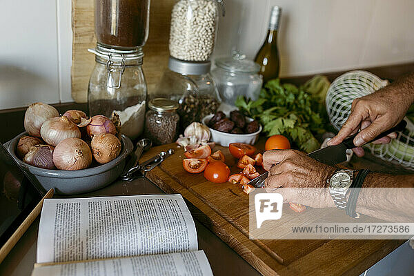 Cropped Bild der menschlichen Hand Schneiden von Tomaten in der Küche zu Hause
