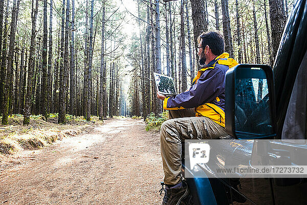 Mann  der im Auto sitzend einen Laptop benutzt  im Nationalpark El Teide  Teneriffa  Spanien