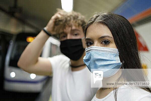 Pärchen mit Gesichtsmasken an einer U-Bahn-Station