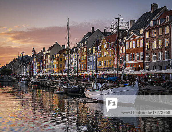 Dänemark  Kopenhagen  Boote an der Nyhavn-Promenade in der Abenddämmerung mit einer Reihe von historischen Stadthäusern im Hintergrund