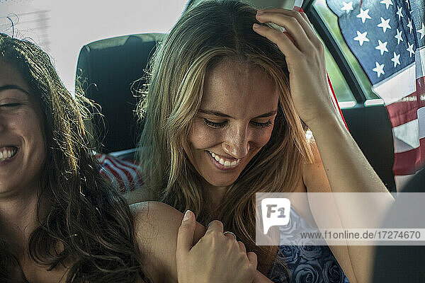 Glückliche Freundinnen im Auto sitzend während einer Autoreise