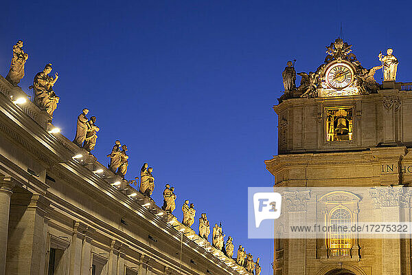 Beleuchtete Heiligenstatuen auf dem Petersdom gegen den klaren blauen Himmel bei Nacht  Vatikanstadt  Rom  Italien