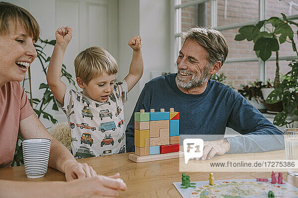 Mutter und Vater spielen mit fröhlichem Sohn Spielzeug-Block-Puzzle zu Hause