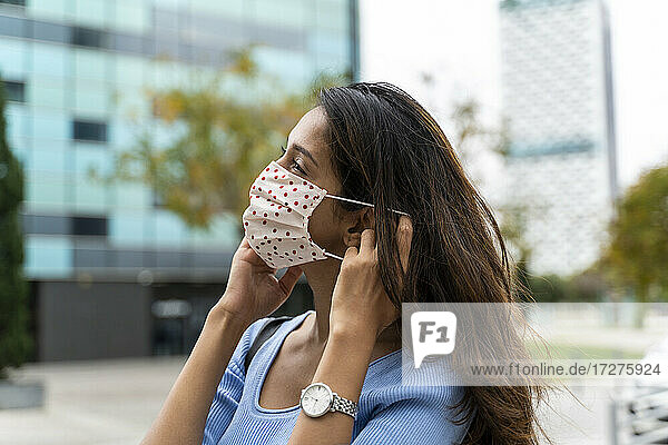 Schöne Frau mit Gesichtsschutzmaske in der Stadt während der COVID-19-Pandemie