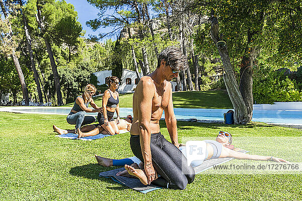 Botschaft Therapeuten behandeln Touristen im Gras liegend in einem Kurort an einem sonnigen Tag