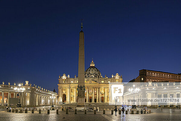 Beleuchteter Petersplatz mit Obelisk und Petersdom bei klarem blauen Himmel in der Nacht  Vatikanstadt  Rom  Italien