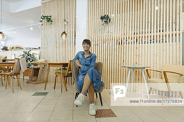Geschäftsfrau sitzt auf einem Stuhl in einem Cafe