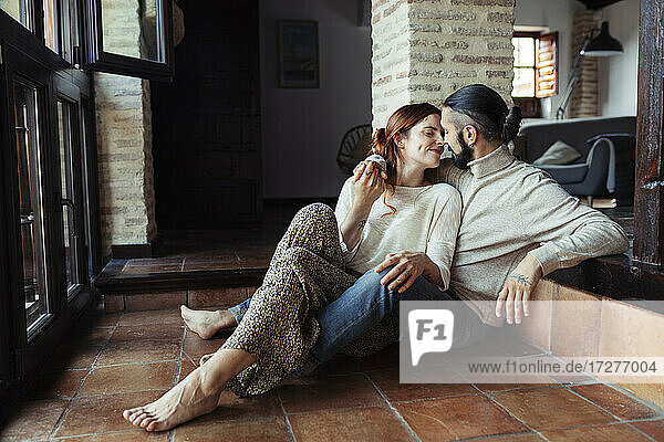 Ehepaar reibt sich die Nase  während es zu Hause auf dem Boden sitzt