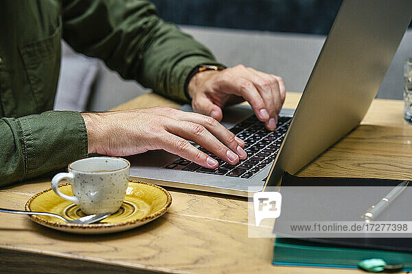 Businessman working on laptop while sitting at cafe