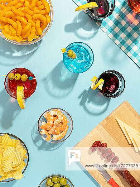 Blau gedeckter Tisch mit verschiedenen Snacks  Vorspeisen und Cocktails